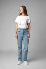 Portrait of a young woman in white T-shirt on gray background