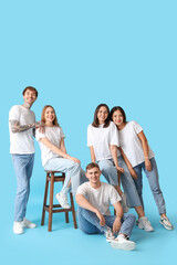 Group of young people in stylish jeans on blue background
