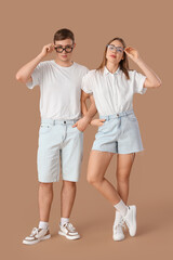 Stylish young couple on brown background