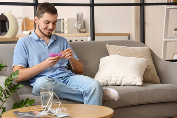 Young man with pill organizer at home