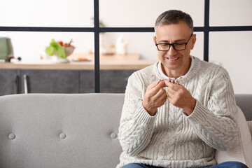 Middle-aged man reading pills description at home