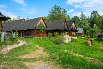Fototapeta na wymiar Old wooden wallachia houses in old village with green meadow in summer. Roznov pod Radhostem. Czech Republic.