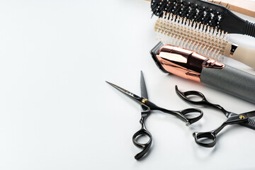 Black hairdressing tools and various hairbrushes on white background