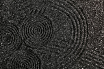 Dark sand with lines, top view. Zen concept