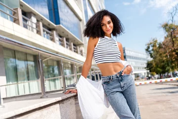Fotobehang Lengtemeter Photo of adorable pretty shiny girl dressed white crop top posing against modern architecture big city sunny spring outside
