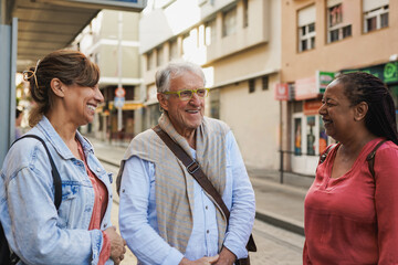 Happy multiracial senior friends meeting each other in the city - Joyful elderly people outdoor