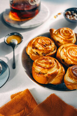 homemade pastries on a plate, light background, no people, close-up, cozy atmosphere, sunlight