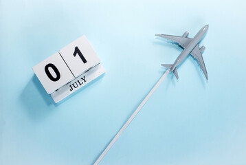 July calendar with number  1. Top view of a calendar with a flying passenger plane. Scheduler....