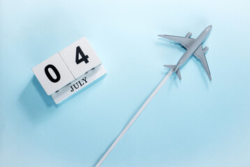 July calendar with number  4. Top view of a calendar with a flying passenger plane. Scheduler....