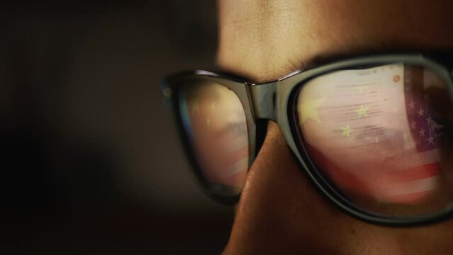 In the reflection of the glasses on a male face, an Internet search engine and the reflection of the Chinese flag turning into the US flag. Cg footage
