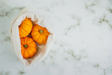 Beautiful little pumpkins on cotton bag. Autumn season concept.