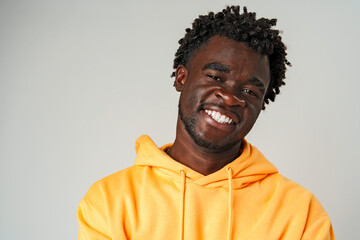 African Man in Yellow Hoodie in Front of Gray Wall