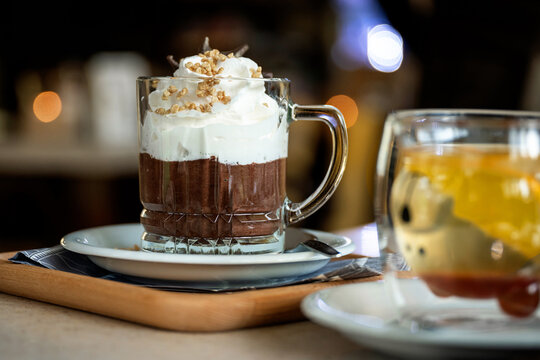 Hot chocolate with whipped cream and chopped nuts in a glass