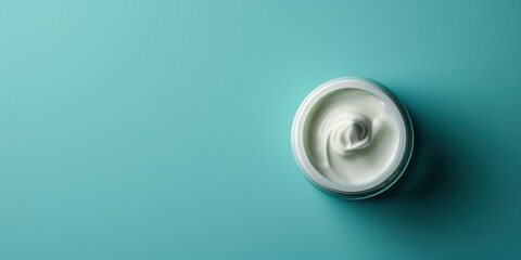 A pot of moisturizer against a calming teal background, suitable for skincare product branding or...
