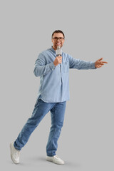 Male journalist with microphone talking on light background