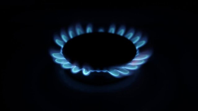 Igniting kitchen gas burner in a dark.