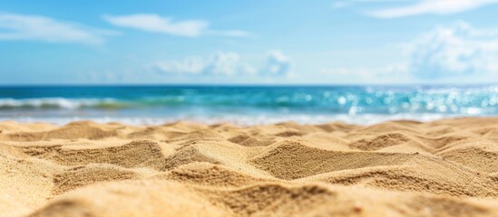 Fototapeta na wymiar Closeup of beach sand with a blurry background of sea water and sky
