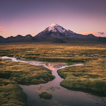 Aerial view of snow capped mountains and vibrant orange sky, Oruro Department, Bolivia.