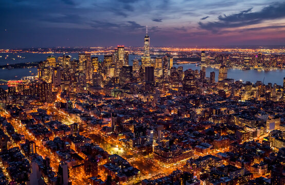 Aerial view of Manhattan at night with illuminated skyscrapers and city lights, New York, United States.