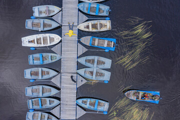 Aerial view of Vuoksi River with moored fishing boats and wooden pier, Larionovskoe, Karelia, Russia.