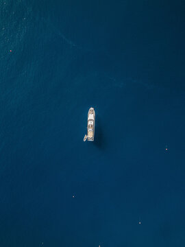 Aerial view of a boat sailing in the sea of Sicily, Italy.