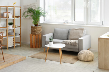 Interior of living room with sofa, table and pouf