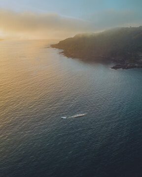 Aerial view of beautiful coastal cliffs over the serene sea at sunset, Galicia, Monteferro, Nigran, Rias Baixas, Spain.