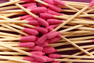 Bamboo cotton swabs buds sticks on a purple background, close-up