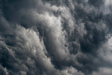 Graue, bedrolhliche Unwetterwolke eines extremen Starkregens mit verwirbelten Wolkenfetzen von unten - obrazy, fototapety, plakaty