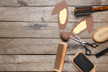 Hairdressing accessories with Easter egg and paper bunny ears on wooden background