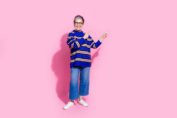 Full length photo of lovely senior lady point banner empty space wear trendy blue striped garment isolated on pink color background