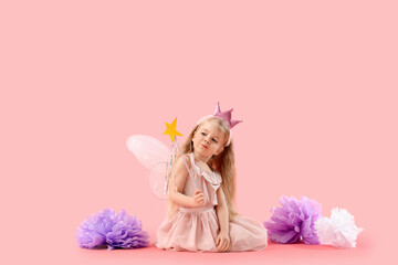 Cute little fairy with magic wand sitting on pink background