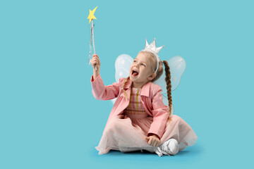 Cute little fairy with wand sitting on blue background