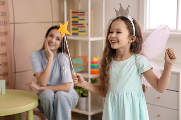 Little girl dressed as fairy with her mother in bedroom