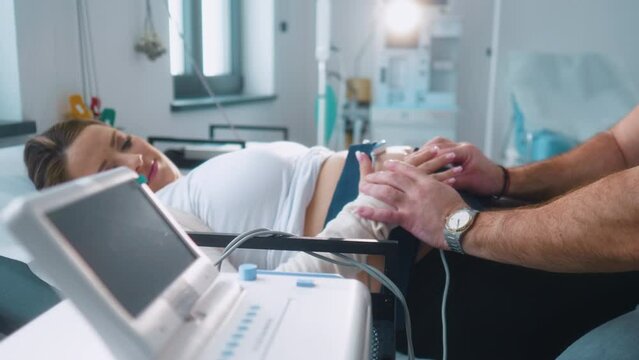 Pregnant woman  performing cardiotocography CTG monitoring fetal heartbeat
