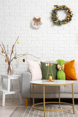 Interior of living room with Easter wreaths and sofa