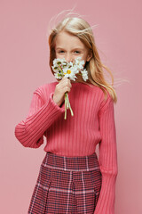 Happy Little Girl Celebrating Mother's Day with a Pink Flower Present A joyful and cute schoolgirl holds a pink flower gift, celebrating Mother's Day in a cheerful and adorable fashion Her blonde hair