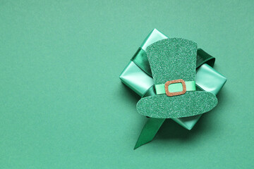 Paper leprechaun hat with gift box on green background. St. Patrick's Day celebration