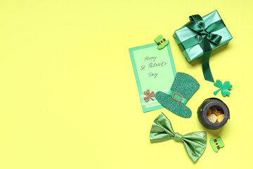 Gift box with festive postcard, bow tie and decor for St. Patrick's Day on yellow background