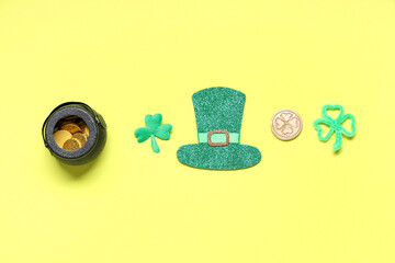 Paper leprechaun hat with pot of coins and decor for St. Patrick's Day on yellow background