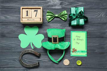 Leprechaun hat with calendar, gift box and horseshoe on grey wooden background. St. Patrick's Day...