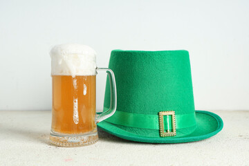 Leprechaun hat with mug of beer on white grunge background. St. Patrick's Day celebration