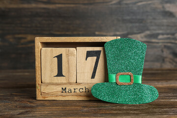 Paper leprechaun hat with calendar on wooden background. St. Patrick's Day celebration