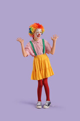 Funny little girl dressed as clown on lilac background. April Fools' Day celebration