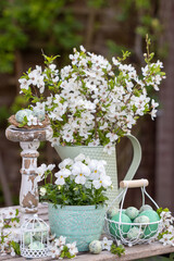 florales Arrangement mit weißem Hornveilchen, Schlehenblüten-Strauß und Wachteleiern 
