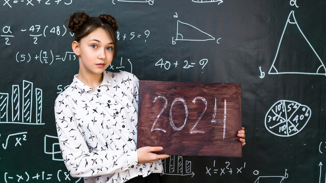 The end of the 2024 school year at the school. Schoolgirl girl with a sign with the numbers 2024