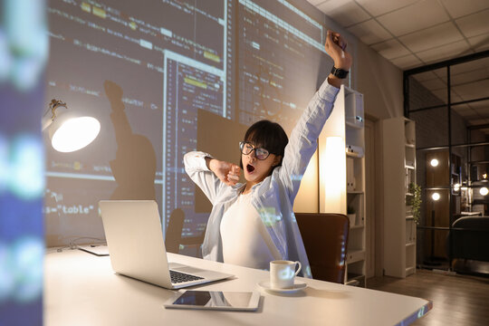 Sleepy young female programmer working in office at night