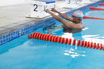 A fit African American male athlete swimmer is preparing to swim