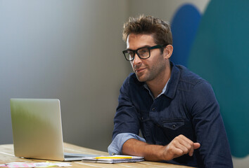 Glasses, creative and man at laptop thinking for ideas, research and reading email in office....