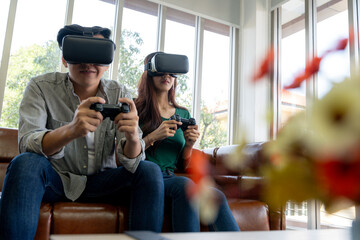 The young couple is having a great time playing VR games at home